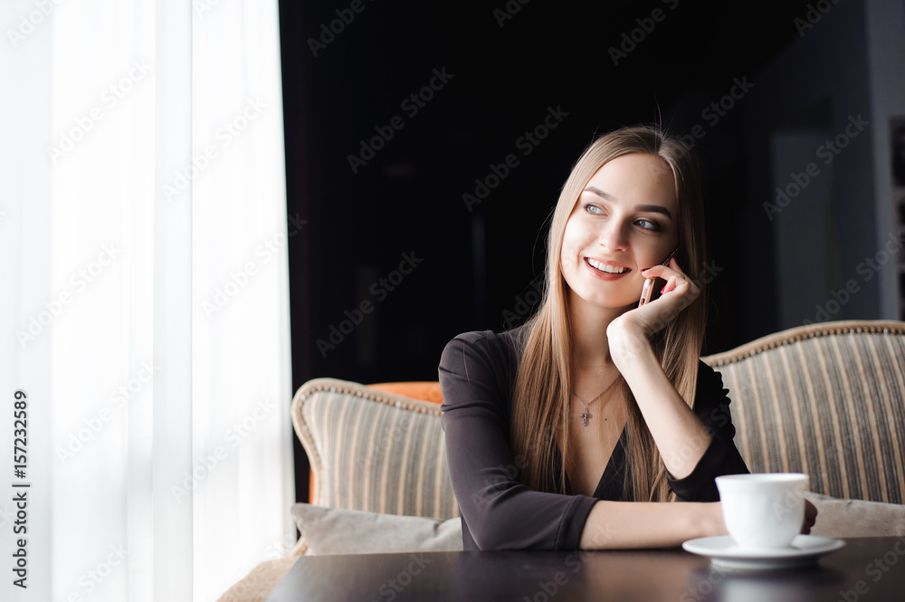 attractive female with cute smile having talking conversation with mobile phone while rest in cafe