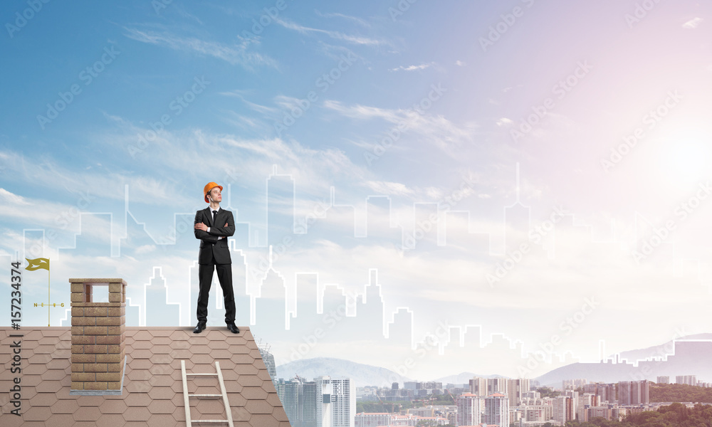 Engineer man standing on roof and looking away. Mixed media Engineer man standing on roof and looking away. Mixed media