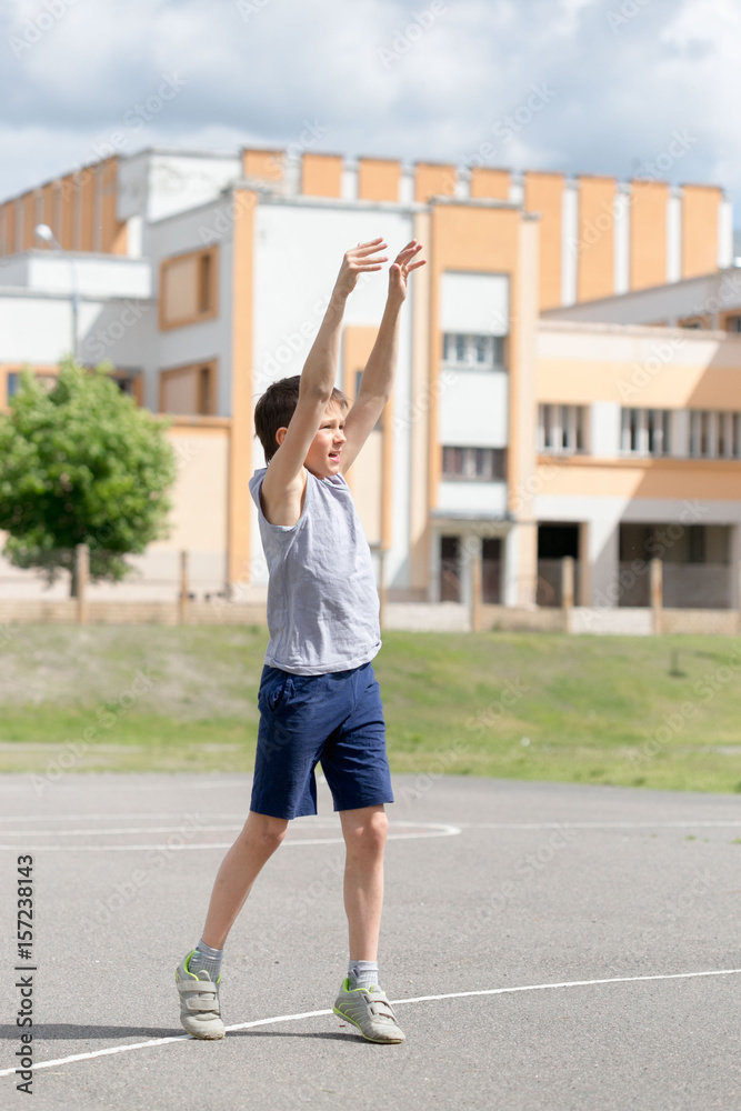 Teenager in a T-shirt and shorts playing with a ball