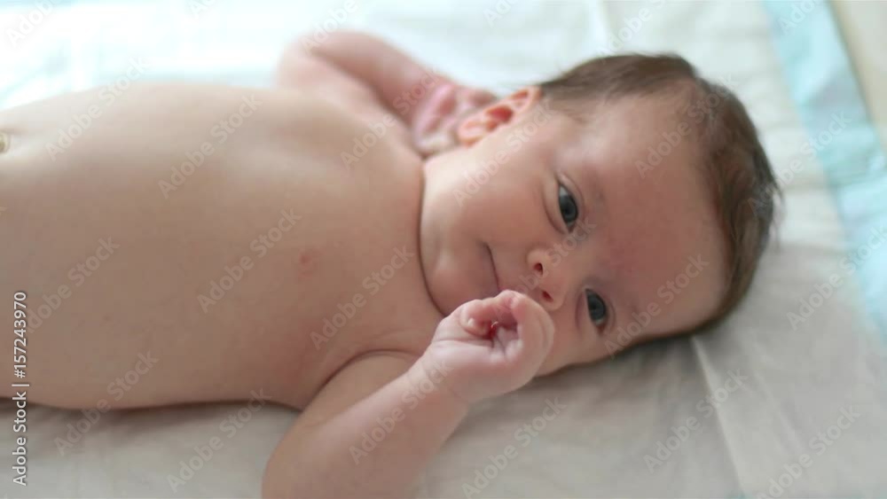 Naked baby is lying on white blanket Naked baby is lying on white blanket