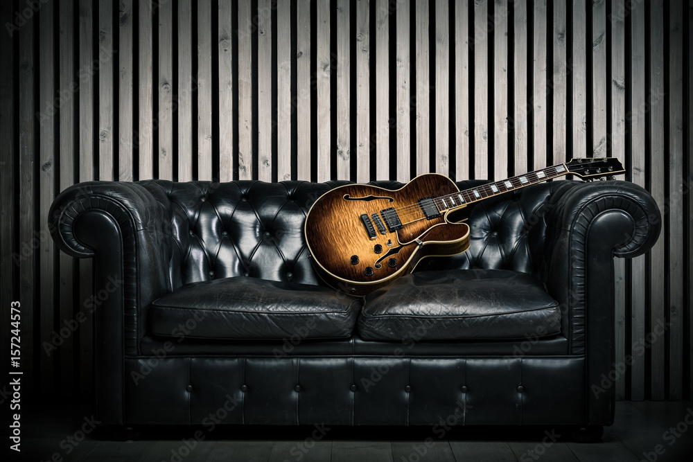 empty vintage sofa and electric guitar with modern wood wall recording  studio background. Music concept with nobody Stock Photo | Adobe Stock