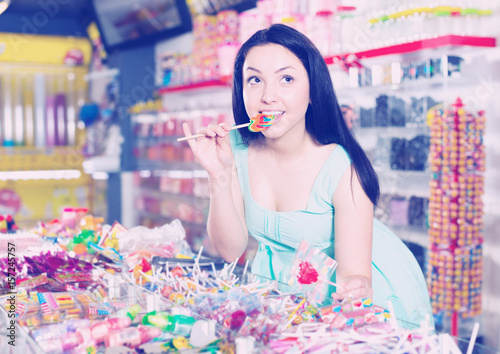 Young shopgirl with lollipop at gifts shop photo