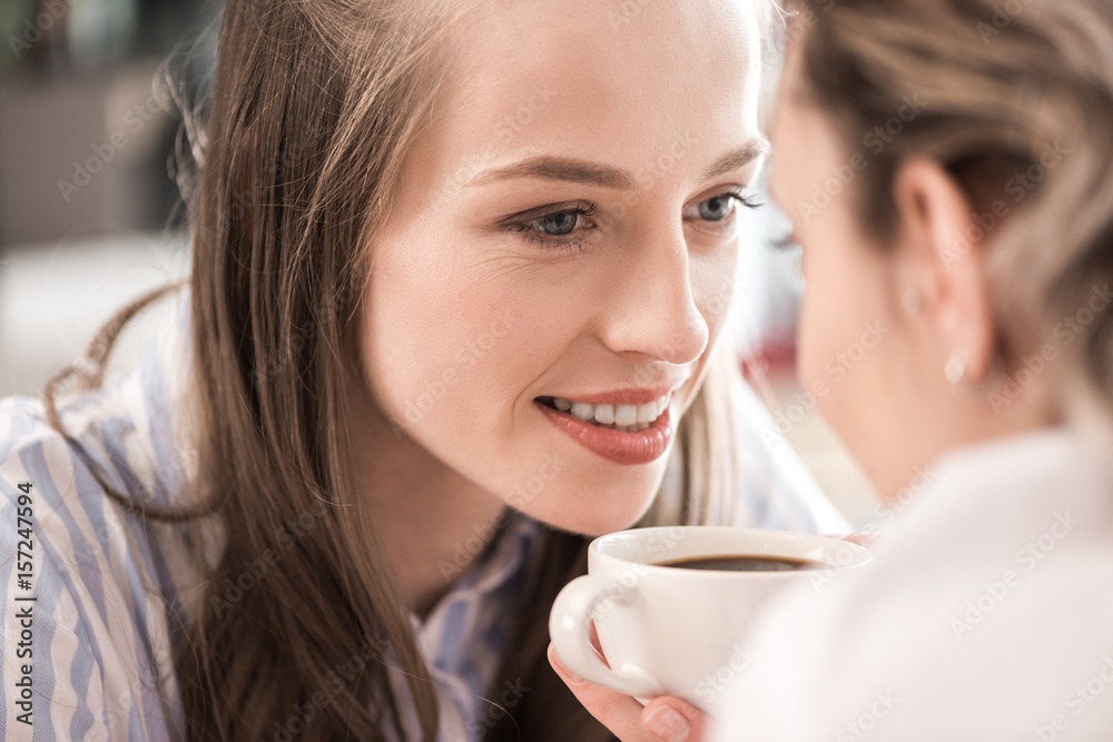 young sensual girlfriends drinking coffee and looking at each other young sensual girlfriends drinking coffee and looking at each other