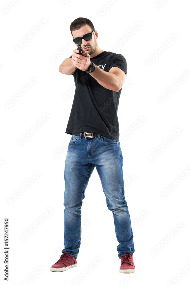 Plain clothes undercover cop aiming gun at viewer wearing sunglasses. Full body length portrait isolated on white studio background. Plain clothes undercover cop aiming gun at viewer wearing sunglasses. Full body length portrait isolated on white studio background.