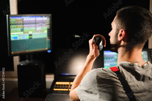 A lighting engineer works with lights technicians control on the concert show. Professional light mixer, mixing console. Equipment for concerts.