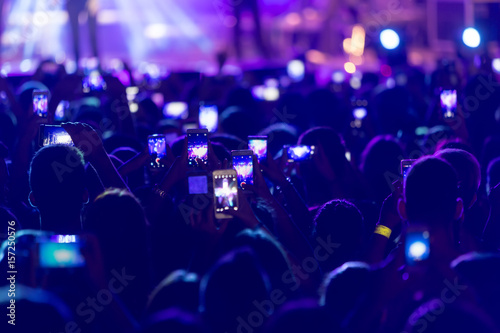 Hand with a smartphone records live music festival