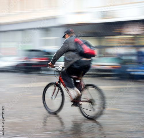 Cyclist on the city roadway in a rainy day