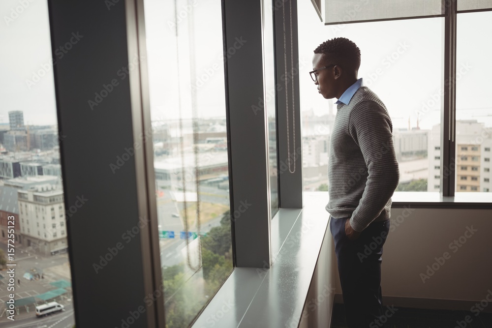 Thoughtful executive looking through window Thoughtful executive looking through window