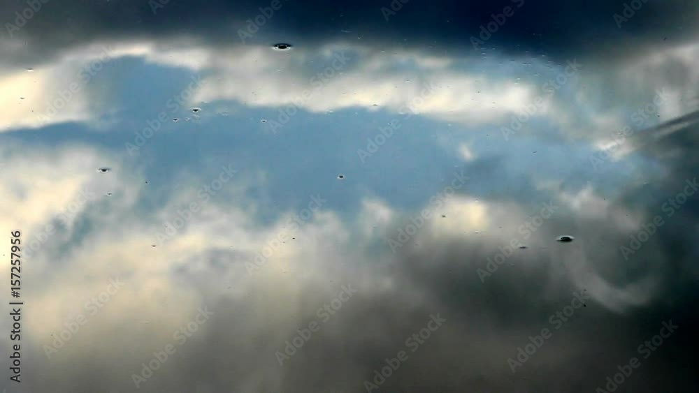 Water surface with ripples and blue sky with clouds reflections Water surface with ripples and blue sky with clouds reflections