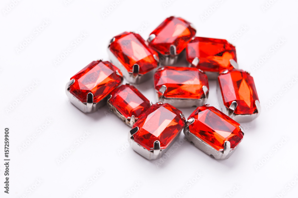 Naklejka premium Ruby loose gemstones pile on white background