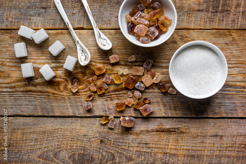 lumps of white and brown sugar on wooden table background top view mock up