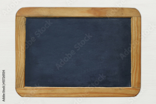 Empty vintage blackboard on white wooden background