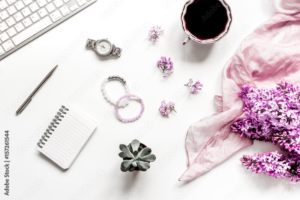 Work desk with lilac flowers in home office on white background top view space for text Work desk with lilac flowers in home office on white background top view space for text