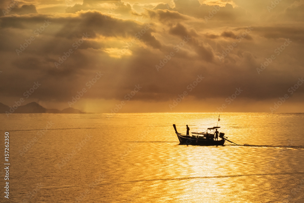 A beautiful golden sunset on the sea,Asian fisherman on wooden boat with sunset time.