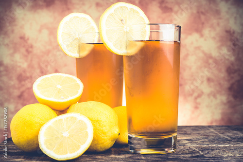 lemon ice tea on wooden table with lemons around
