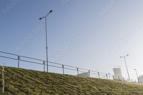 city embankment with street light and construction in a blue sky background