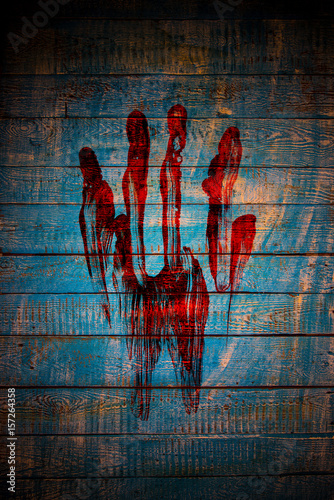 Bloody fingerprint on old wooden background. photo