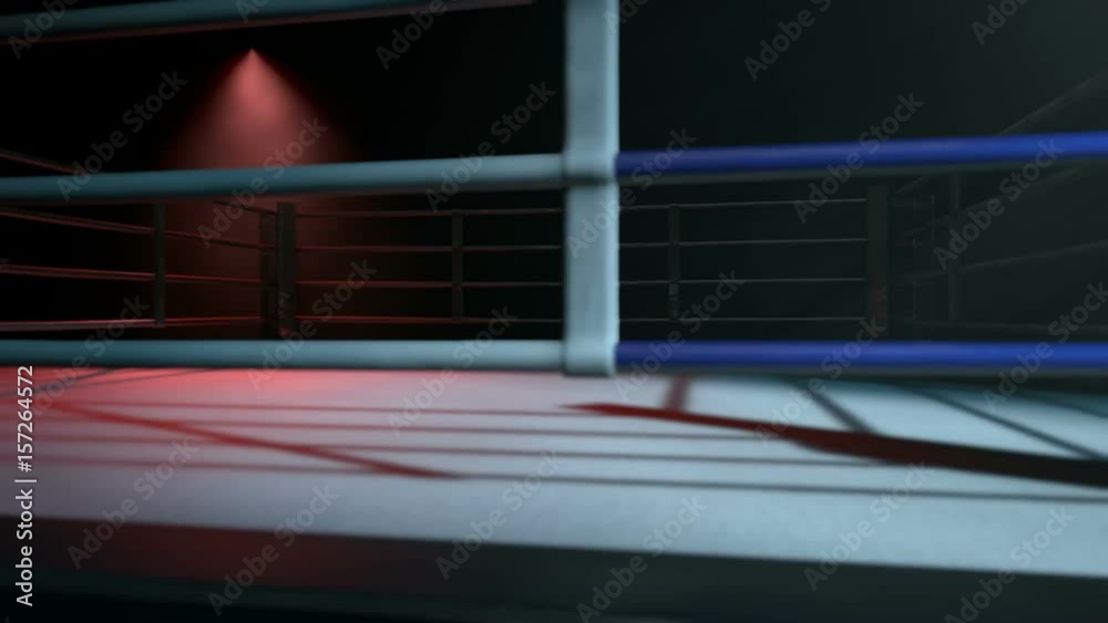 A pan across a empty regular boxing ring surrounded by ropes spotlit in either opposing corner on an isolated dark background A pan across a empty regular boxing ring surrounded by ropes spotlit in either opposing corner on an isolated dark background