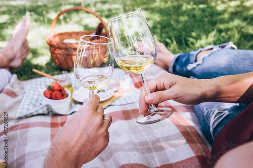 Couple in love drinks a white wine on summer picnic photo
