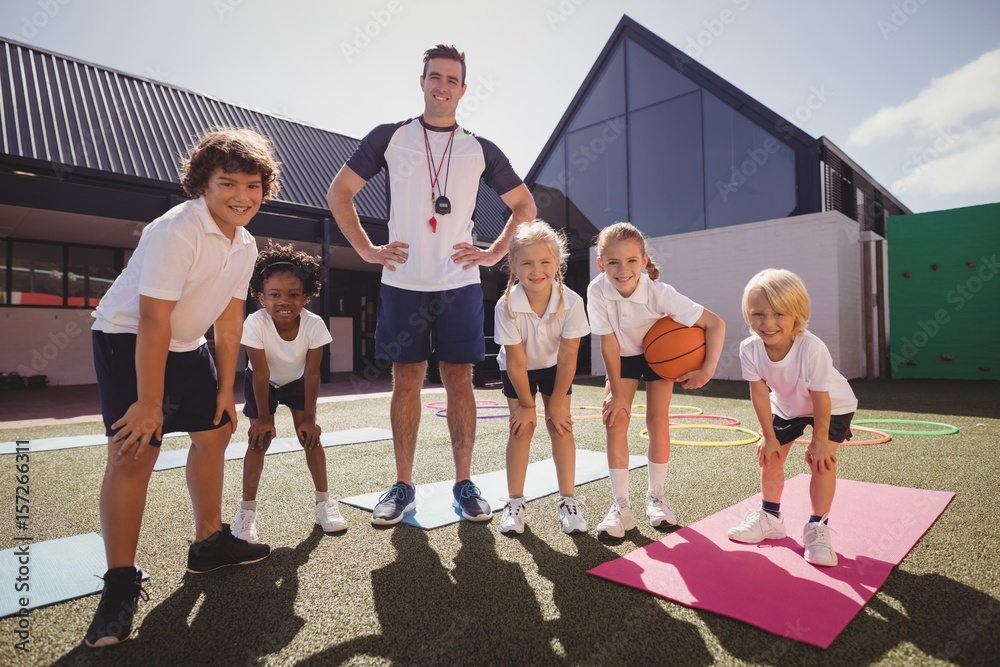 Obraz premium Portrait of happy coach and schoolkids