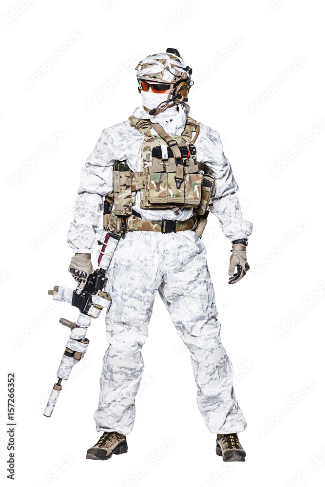 Special forces operator of Navy Seals armed with assault rifle with closed face in polarized sunglasses and military winter camo clothes designed to operations in extreme conditions. Studio shot Special forces operator of Navy Seals armed with assault rifle with closed face in polarized sunglasses and military winter camo clothes designed to operations in extreme conditions. Studio shot