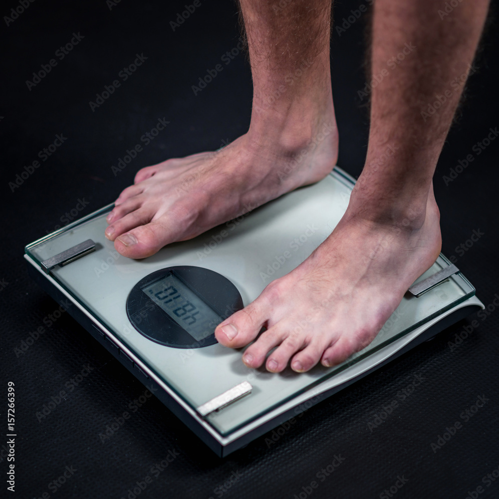 Fototapeta premium measuring weight of teenage boy