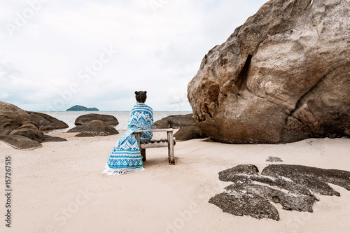 beautiful young woman wrapped in a blanket on the beach