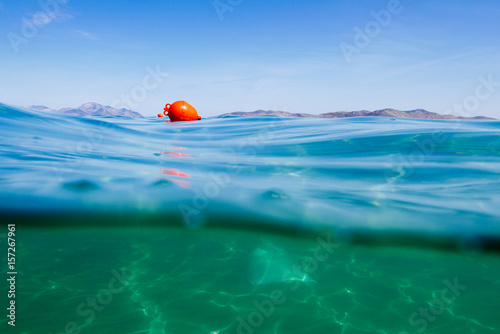 Obraz na płótnie Marker buoy on surface of water. View half and half underwater. w salonie