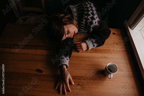 Woman lying on table with mug