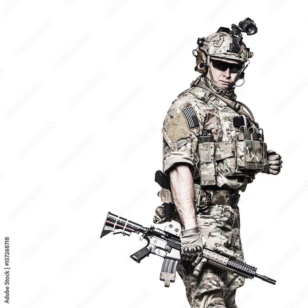 Elite member of US Army rangers in combat uniforms with his shirt sleeves  rolled up, in helmet, eyewear and night vision goggles. Studio shot, white  background, looking at camera, dark contrast foto
