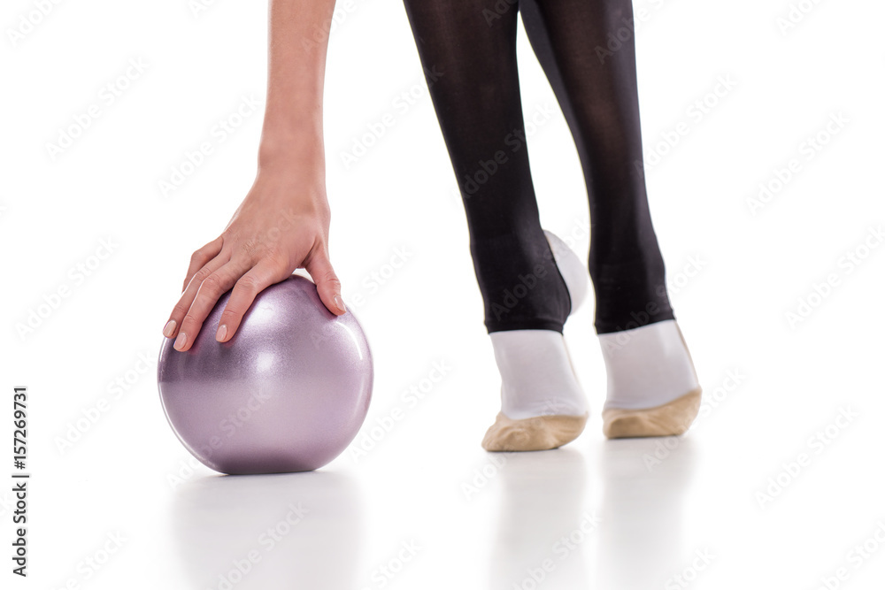 Close-up partial view of rhythmic gymnast exercising with ball isolated on white