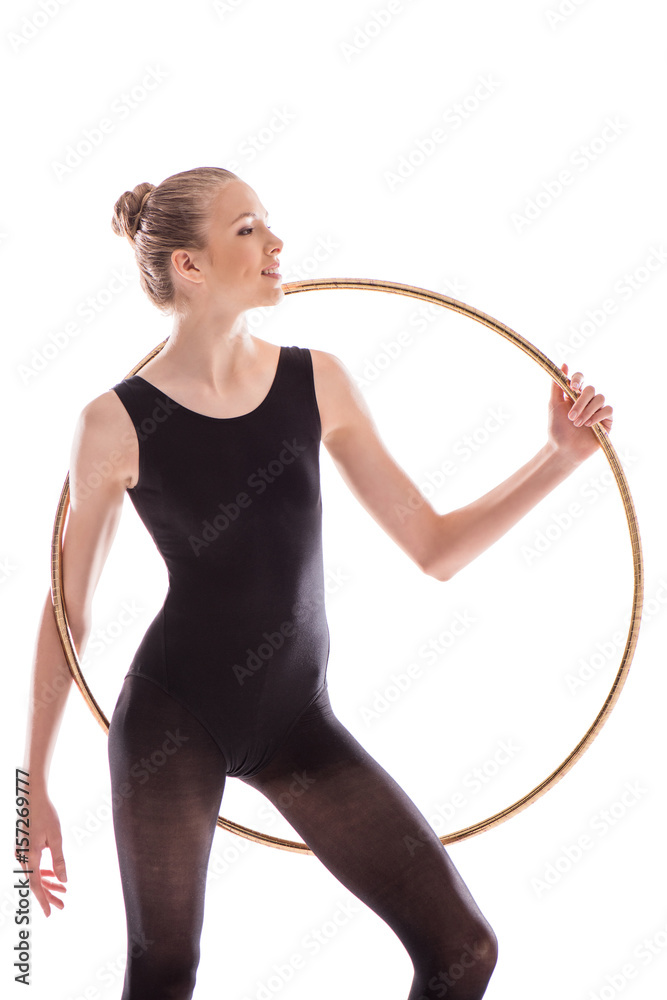 Attractive young sportswoman in bodysuit doing rhythmic gymnastics exercise with hoop Attractive young sportswoman in bodysuit doing rhythmic gymnastics exercise with hoop