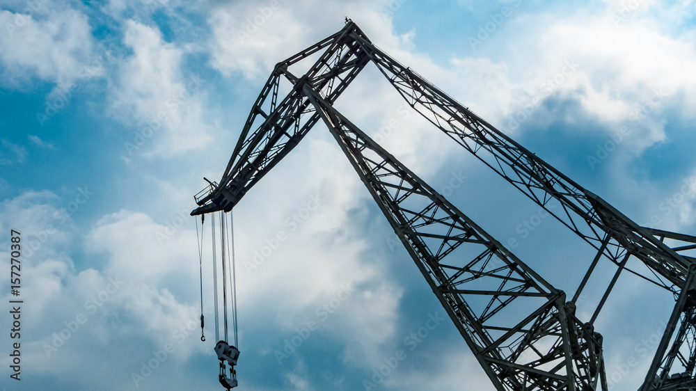 Crane Construction against blue sky background. Steel industry crane at sea port, image for transportation, heavy industry construction concept