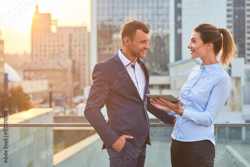 Smiling business people with tablet. Happy woman and man, city. How to impress your boss.