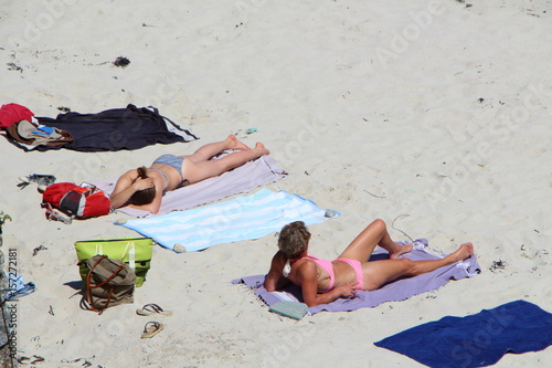 Femmes bronzant à la plage photo