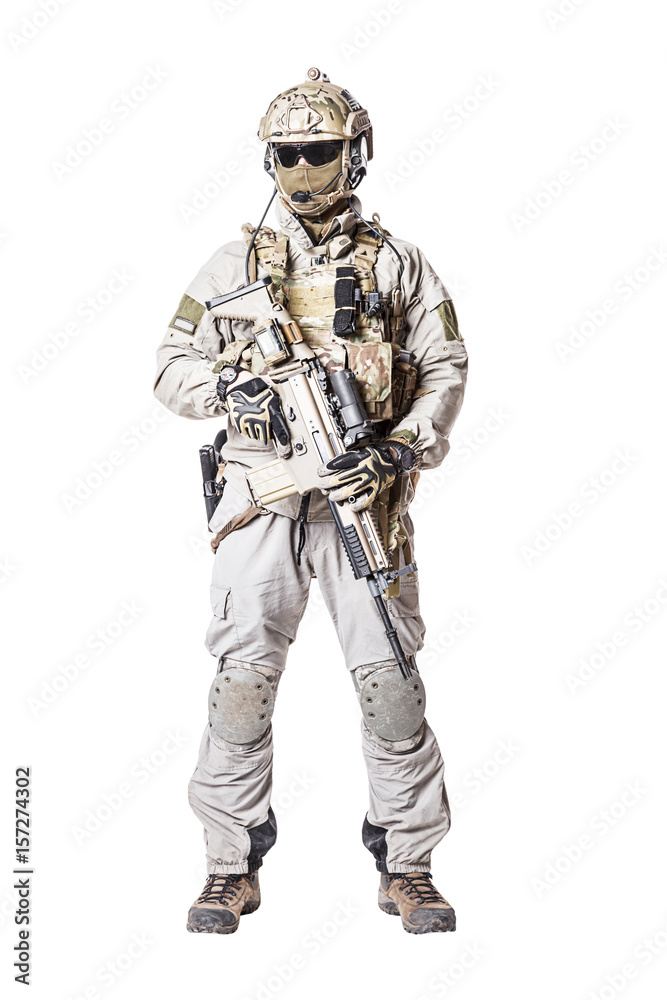 Army soldier in Protective Combat Uniform holding Special Operations Forces Combat Assault Rifle. Knee pads, mag recovery pouch, chest rig, military boots. Studio shot, isolated on white background Army soldier in Protective Combat Uniform holding Special Operations Forces Combat Assault Rifle. Knee pads, mag recovery pouch, chest rig, military boots. Studio shot, isolated on white background