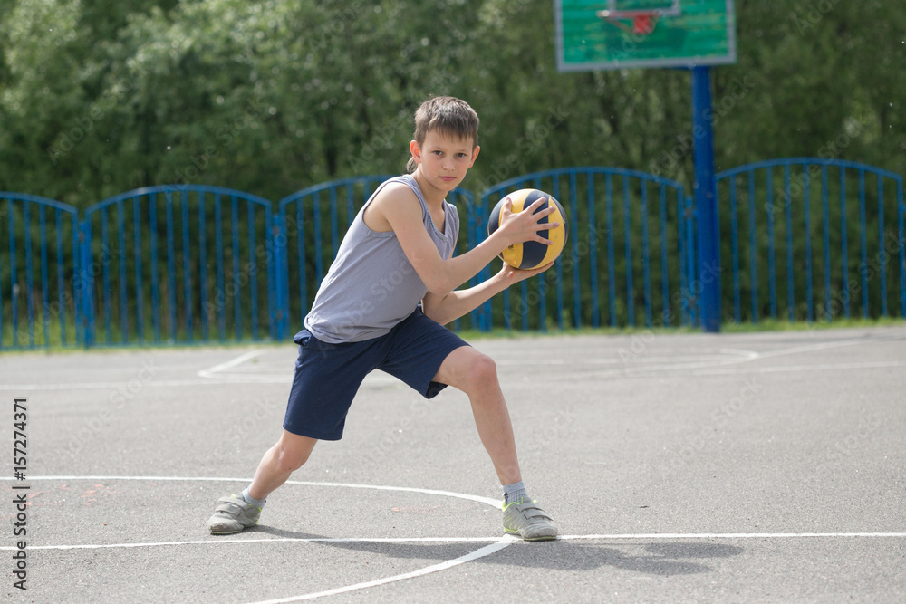 Teenager in a T-shirt and shorts playing with a ball