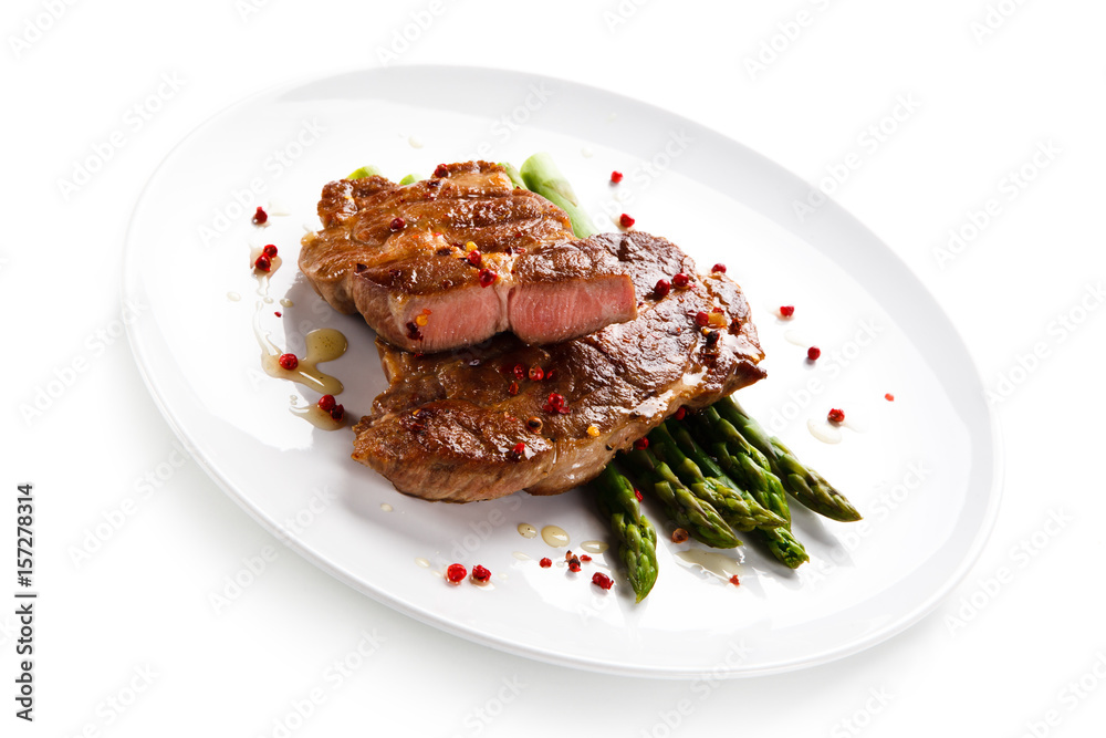 Grilled beefsteak with asparagus on white background