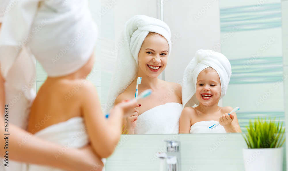 Mother and child daughter brush their teeth with toothbrush. Mother and child daughter brush their teeth with toothbrush.
