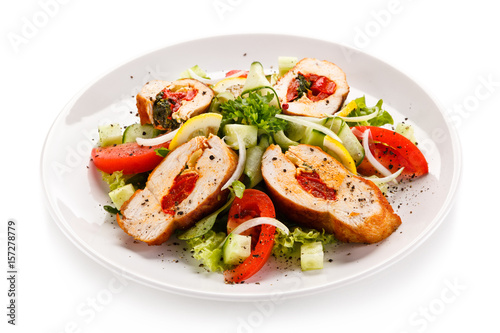 Salad with stuffed chicken fillet on white background