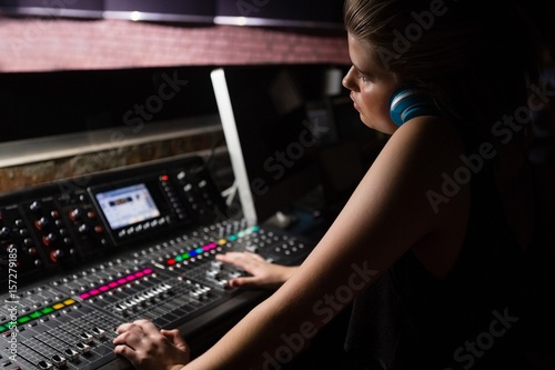 Female audio engineer using sound mixer