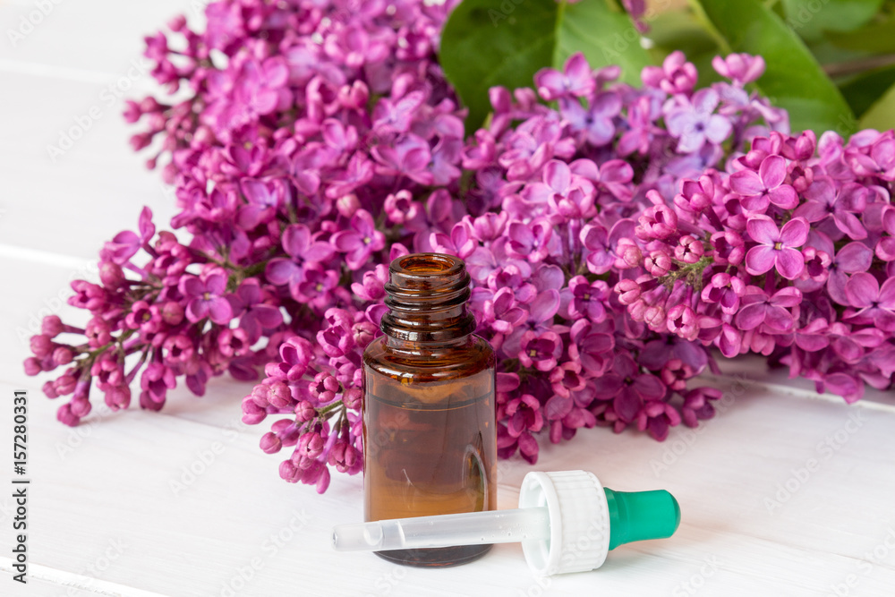 Bottle with aroma oil and lilac flowers Bottle with aroma oil and lilac flowers