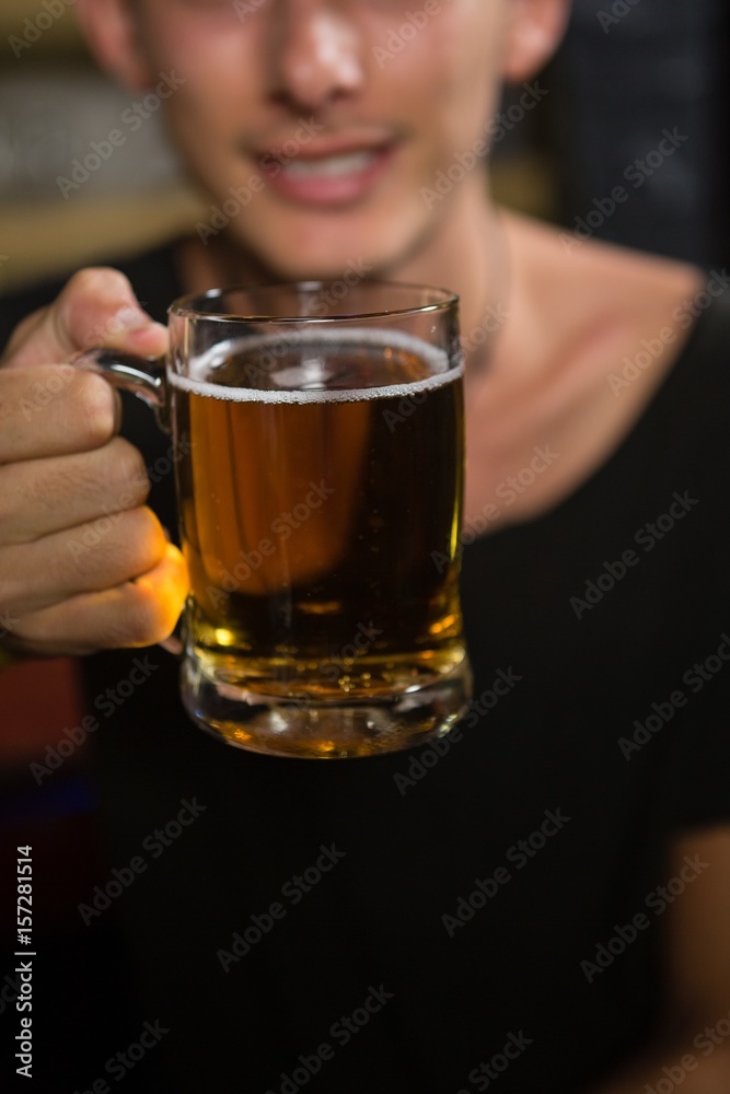 Man holding a mug of beer in bar Man holding a mug of beer in bar