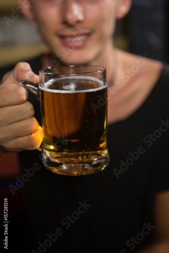 Man holding a mug of beer in bar