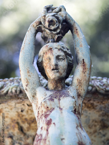 Rusty garden scupture figuring a woman from the sea. photo