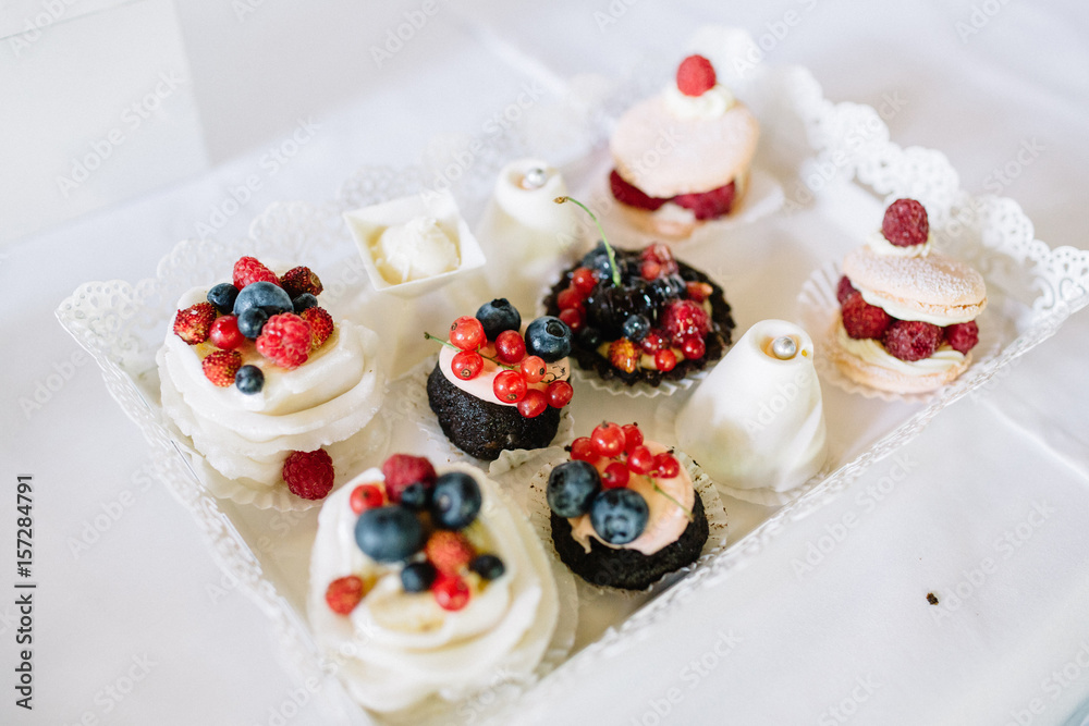 Sweets decorated with berries and served on glass dish Sweets decorated with berries and served on glass dish