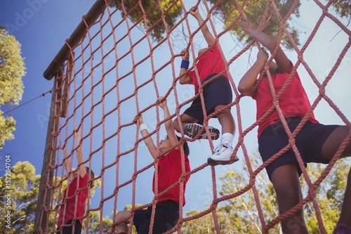 Kids climbing a net during obstacle course training
