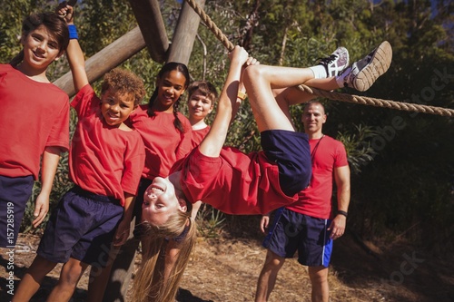 Kids climbing a traverse rope during obstacle course training