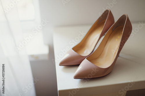 Beige shoes for a birde stand on the dressing table