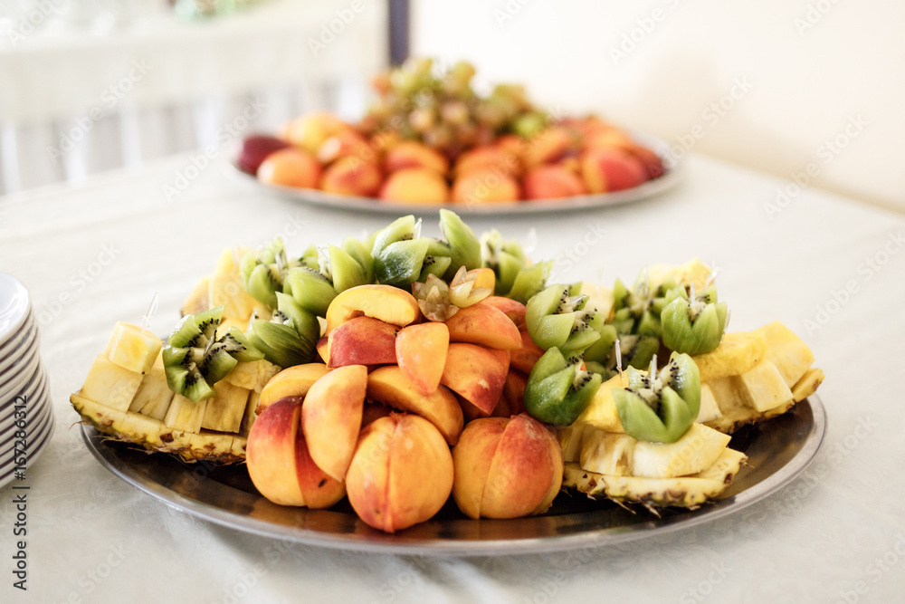 Pieces of kiwi and peaches served on the dish Pieces of kiwi and peaches served on the dish